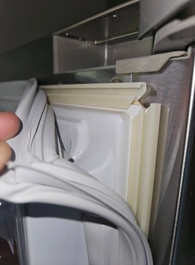 Close up of a fridge door seal being replaced