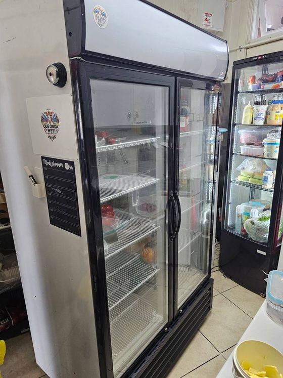 Double glass door display fridge and countertop unit being serviced in a restaurant